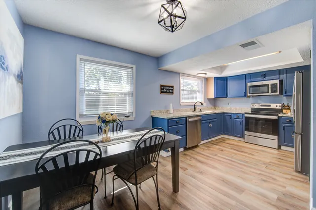 a kitchen with a table chairs microwave and cabinets