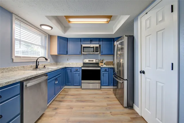 a kitchen with granite countertop a refrigerator and a sink
