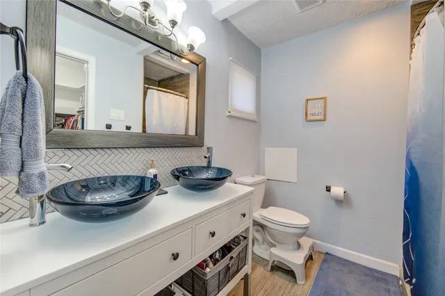 a bathroom with a toilet a sink and mirror