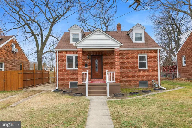 a view of a house with a yard and large tree