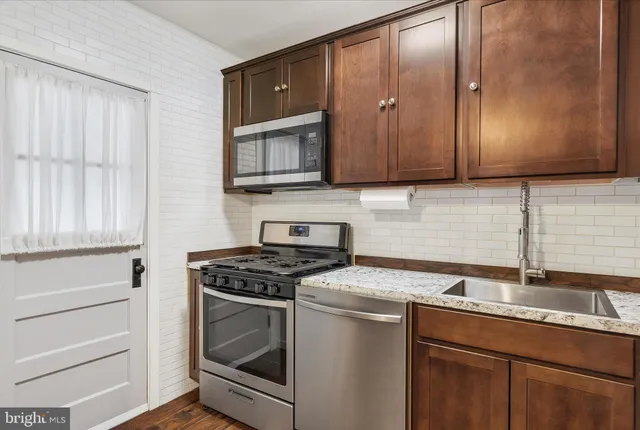 a kitchen with granite countertop cabinets stainless steel appliances and a sink