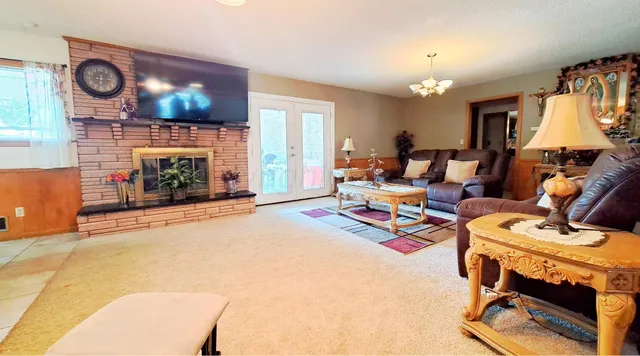 a living room with furniture a fireplace and a flat screen tv