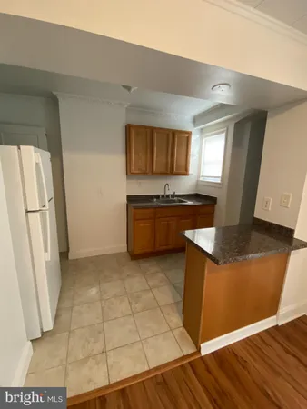 a kitchen with granite countertop a refrigerator and a sink
