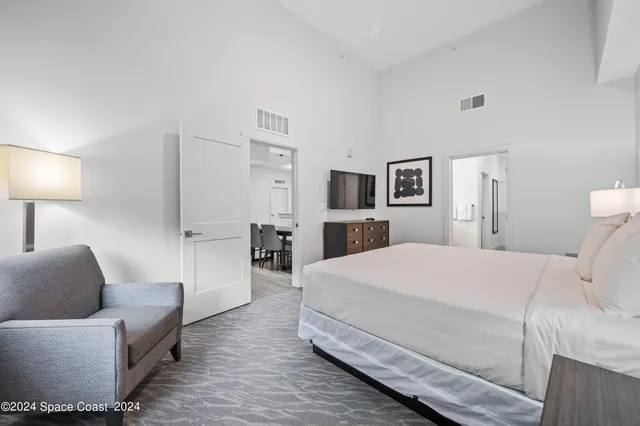 a bedroom with a bed and a flat screen tv