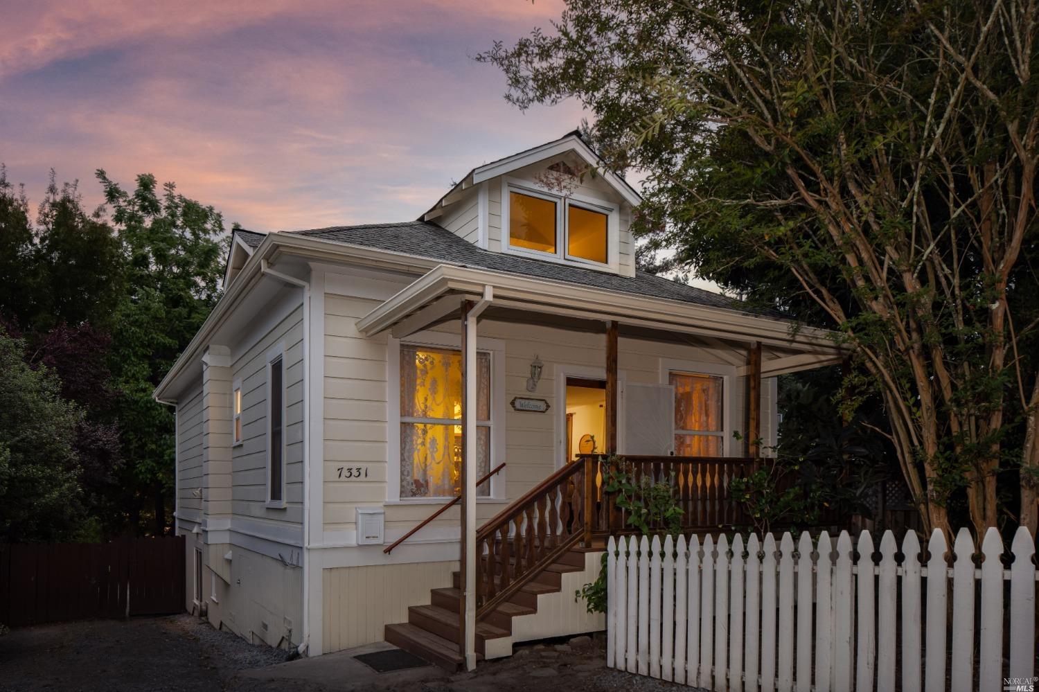 a front view of a house with a tree