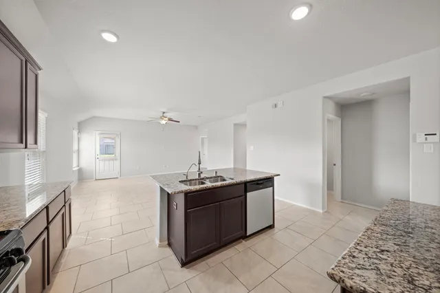 a kitchen with stainless steel appliances granite countertop a sink and a stove