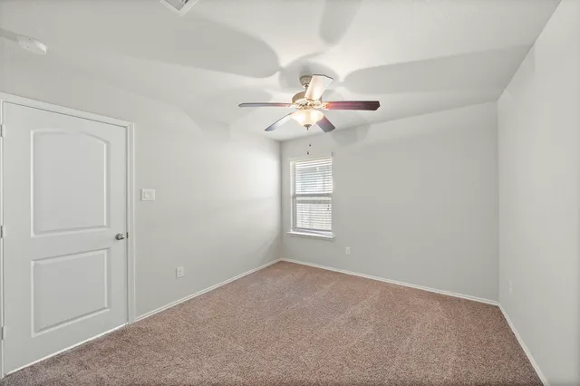 a view of a room with a ceiling fan and a window