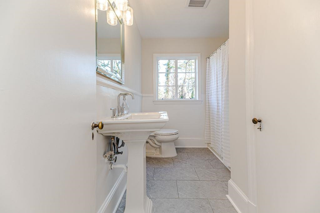 2618 Wade Avenue Raleigh, NC 27607 - Photo 32 of 62 a bathroom with a sink a toilet and mirror