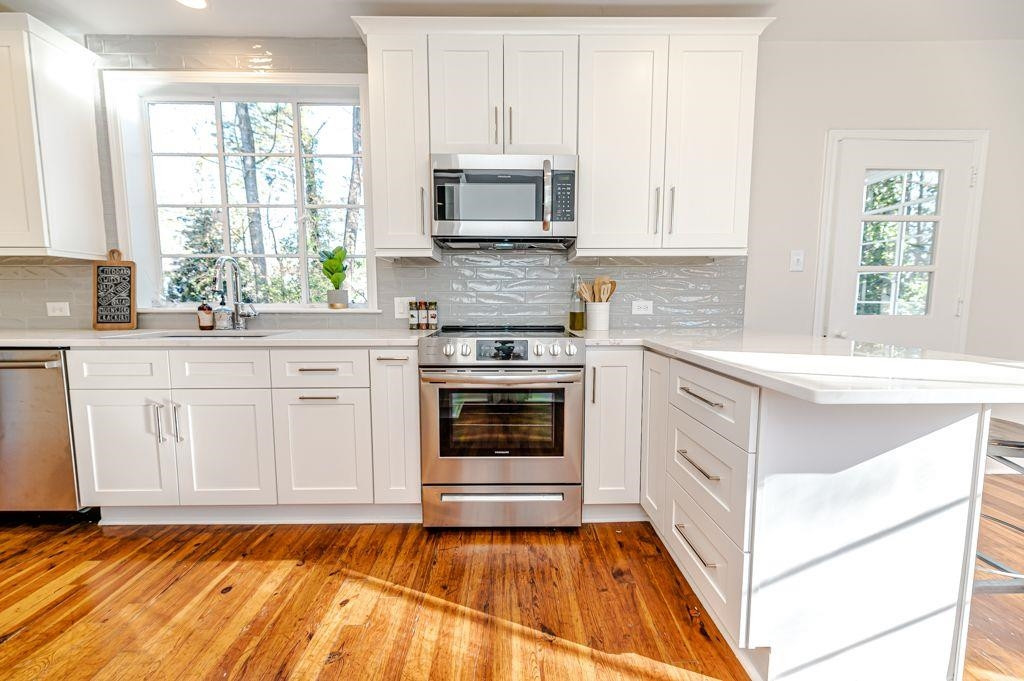 2618 Wade Avenue Raleigh, NC 27607 - Photo 43 of 62 a kitchen with granite countertop a stove a sink and a microwave