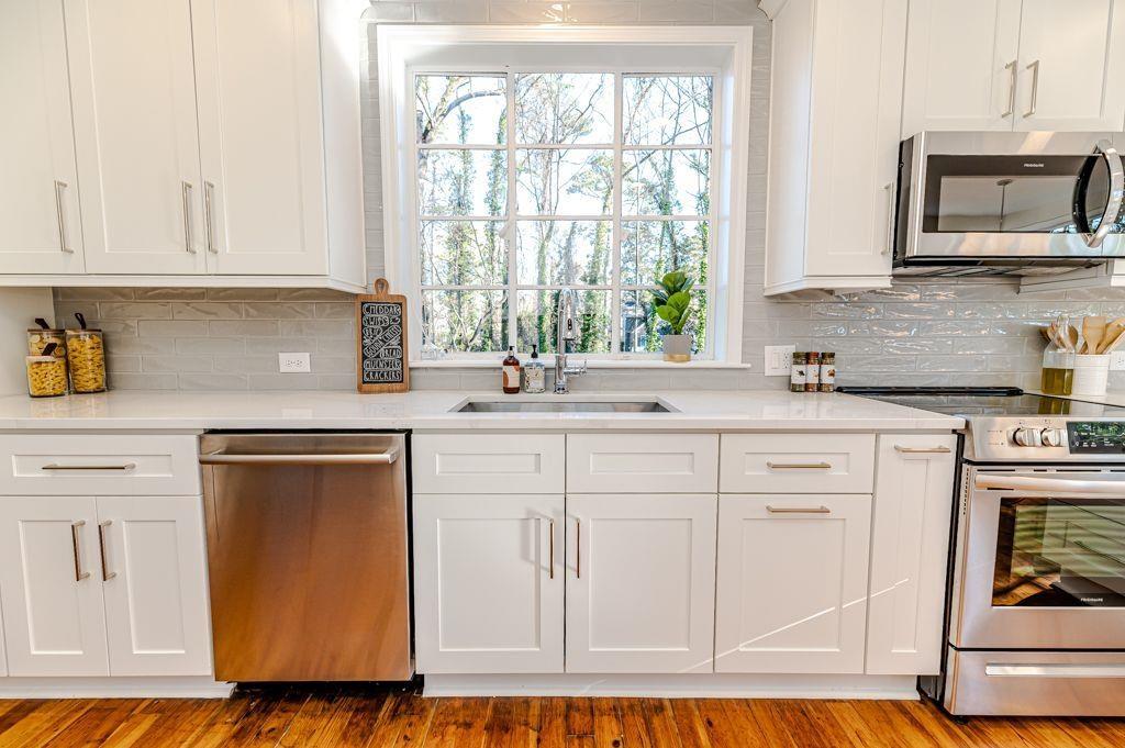 2618 Wade Avenue Raleigh, NC 27607 - Photo 44 of 62 a kitchen with white cabinets and white appliances