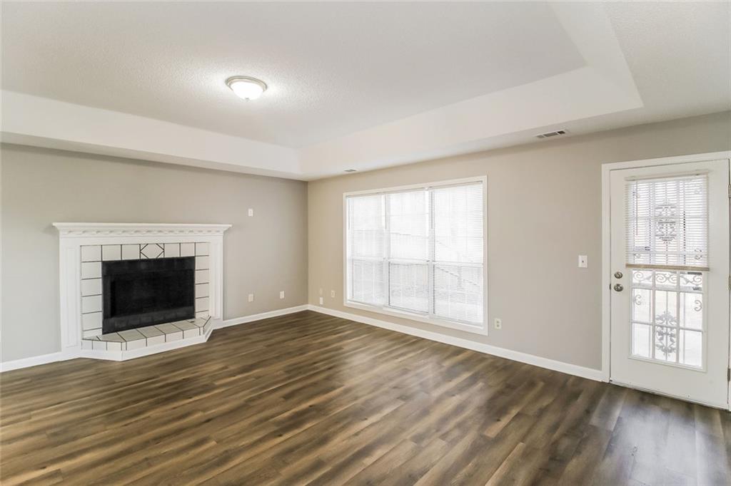 4358 Wesleyan Pointe Decatur, GA 30034 - Photo 13 of 30 an empty room with wooden floor fireplace and windows