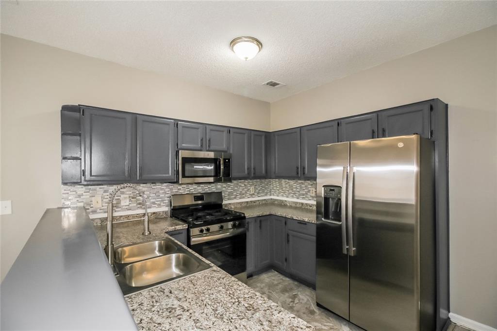 4358 Wesleyan Pointe Decatur, GA 30034 - Photo 15 of 30 a kitchen with stainless steel appliances granite countertop a refrigerator stove and sink