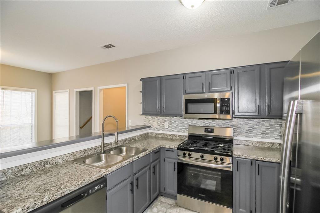 4358 Wesleyan Pointe Decatur, GA 30034 - Photo 16 of 30 a kitchen with granite countertop a sink stove and refrigerator