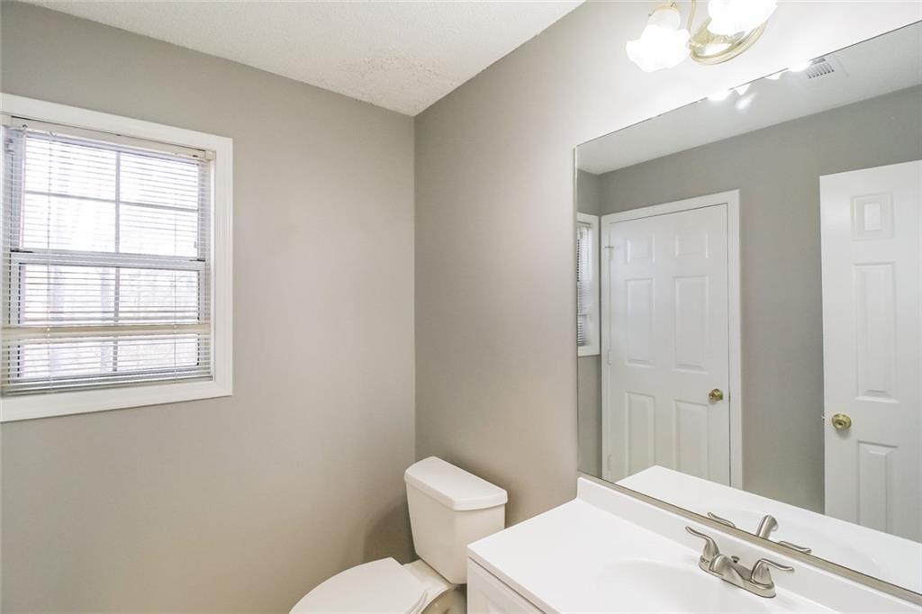 4358 Wesleyan Pointe Decatur, GA 30034 - Photo 10 of 30 a bathroom with a toilet a sink a mirror and a window