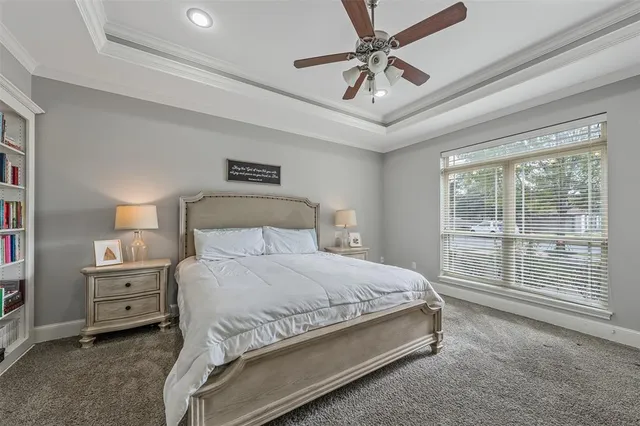 a bedroom with a large bed and a chandelier