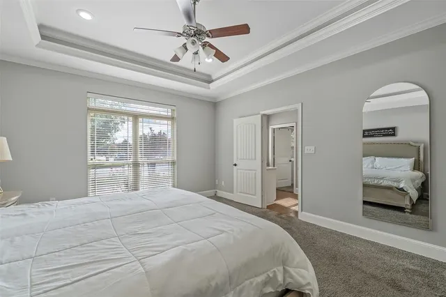 a bedroom with a large bed and a chandelier