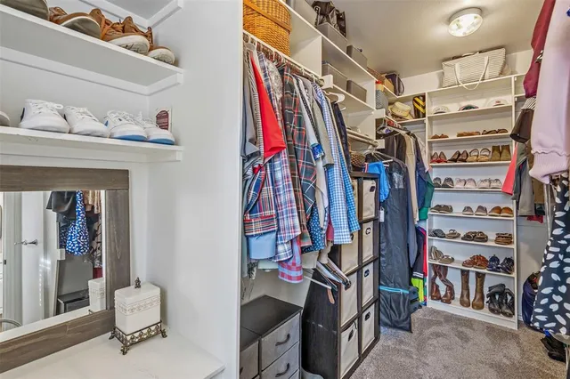 a view of walk in closet with clothes and shoes
