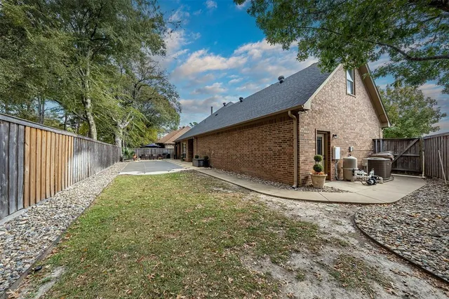 a view of a house with backyard and trees