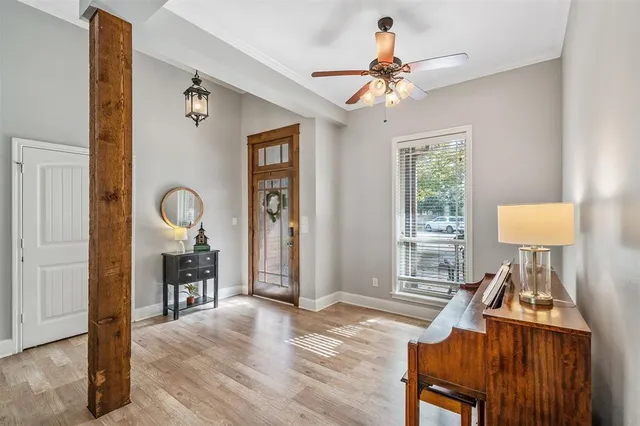 a view of a livingroom with furniture a chandelier fan and wooden floor