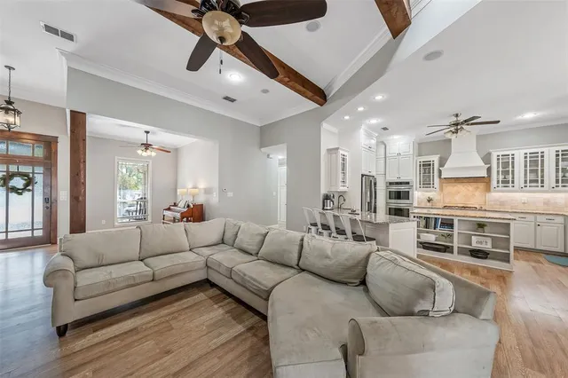 a living room with furniture kitchen view and a chandelier