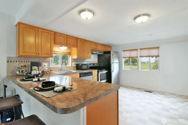 a kitchen with stainless steel appliances granite countertop a sink a stove and a refrigerator