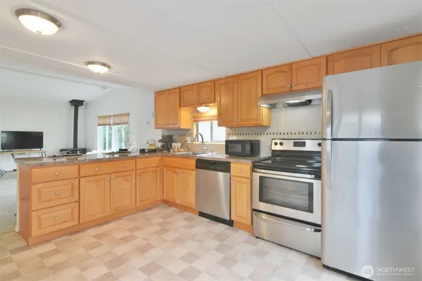 a kitchen with stainless steel appliances granite countertop a refrigerator sink and stove