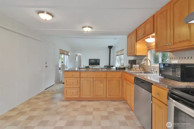a kitchen with stainless steel appliances granite countertop a sink and cabinets