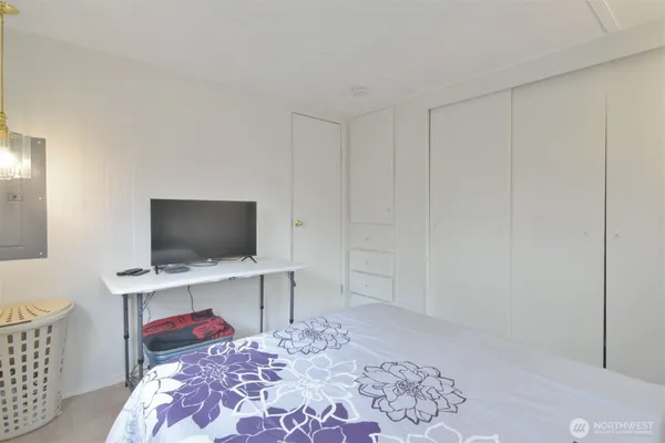 a bedroom with a bed and a flat screen tv