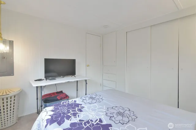 a bedroom with a bed and a flat screen tv