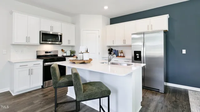 a kitchen with a sink stainless steel appliances and white cabinets