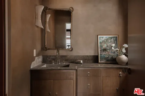 a bathroom with a granite countertop sink and a mirror