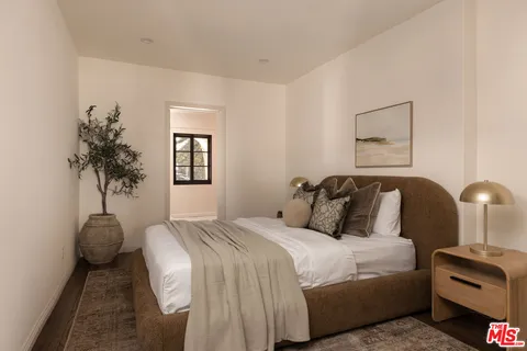 a bedroom with bed and a potted plant