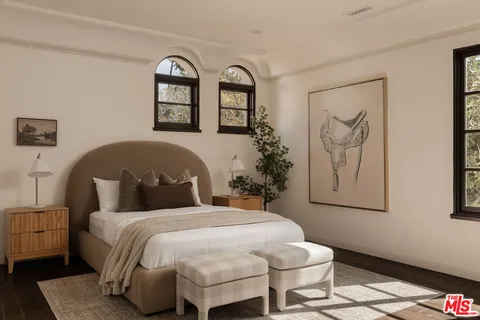 a bedroom with a bed and a painting on the wall