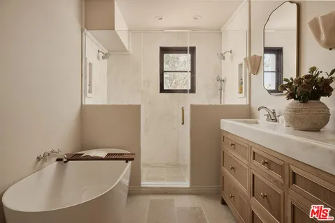 a bathroom with a tub sink and mirror