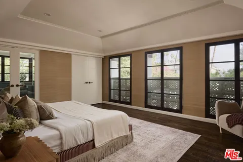 a bedroom with a large bed and a large window