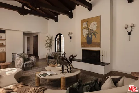 a living room with furniture a fireplace and wall paintings