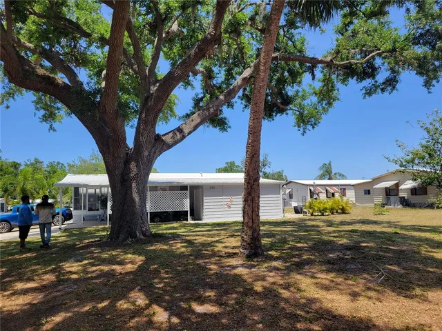 a view of a yard in front of a house with a large tree