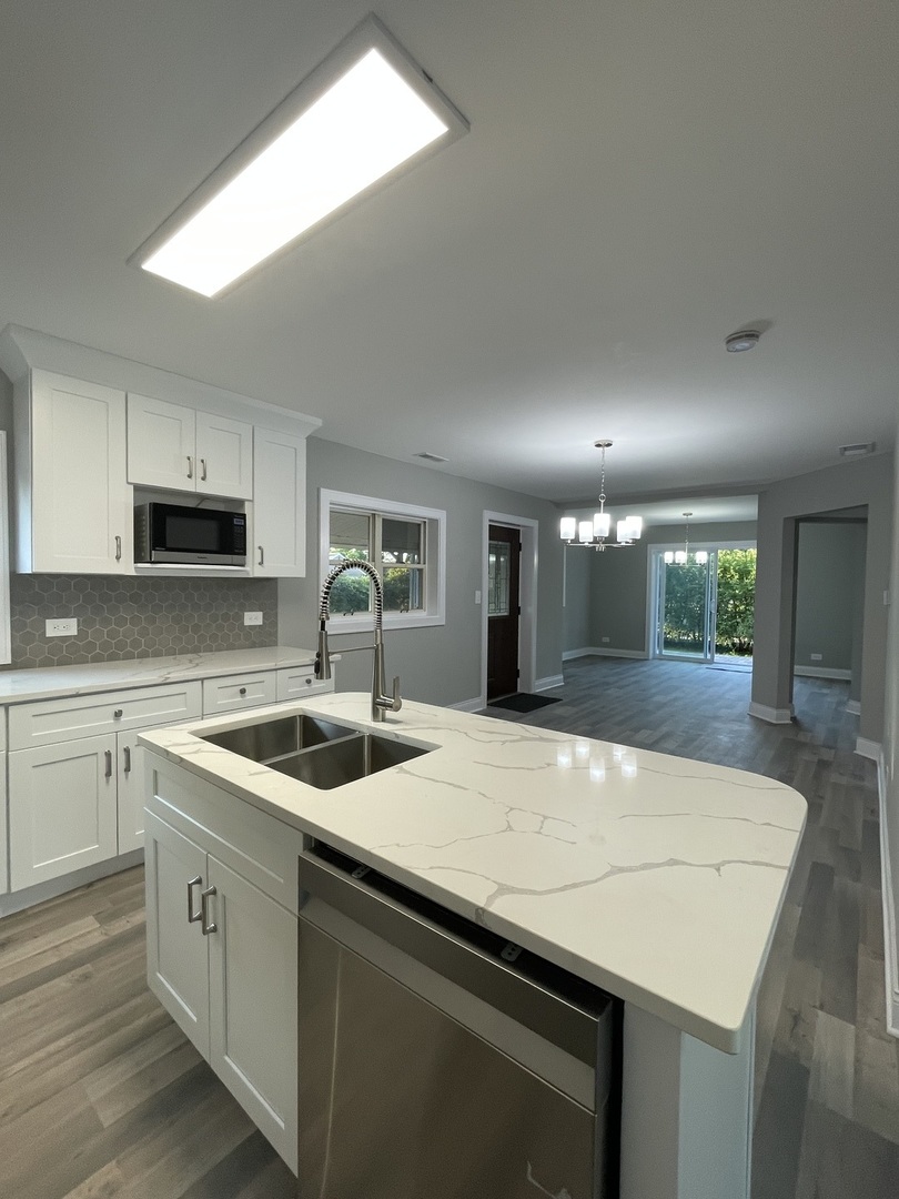 5547 South Peck Avenue Countryside, IL 60525 - Photo 11 of 26 a kitchen with granite countertop a sink and white cabinets