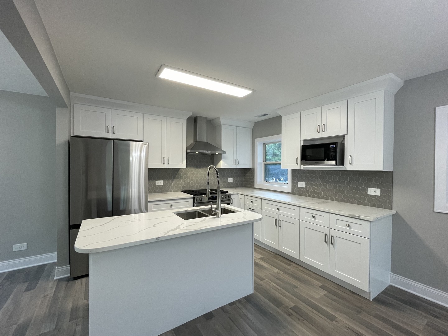 5547 South Peck Avenue Countryside, IL 60525 - Photo 9 of 26 a kitchen with white cabinets stainless steel appliances and sink