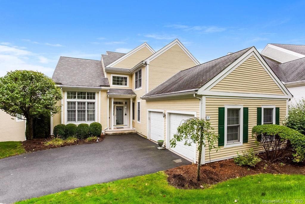 a view of a white house next to a yard and plants