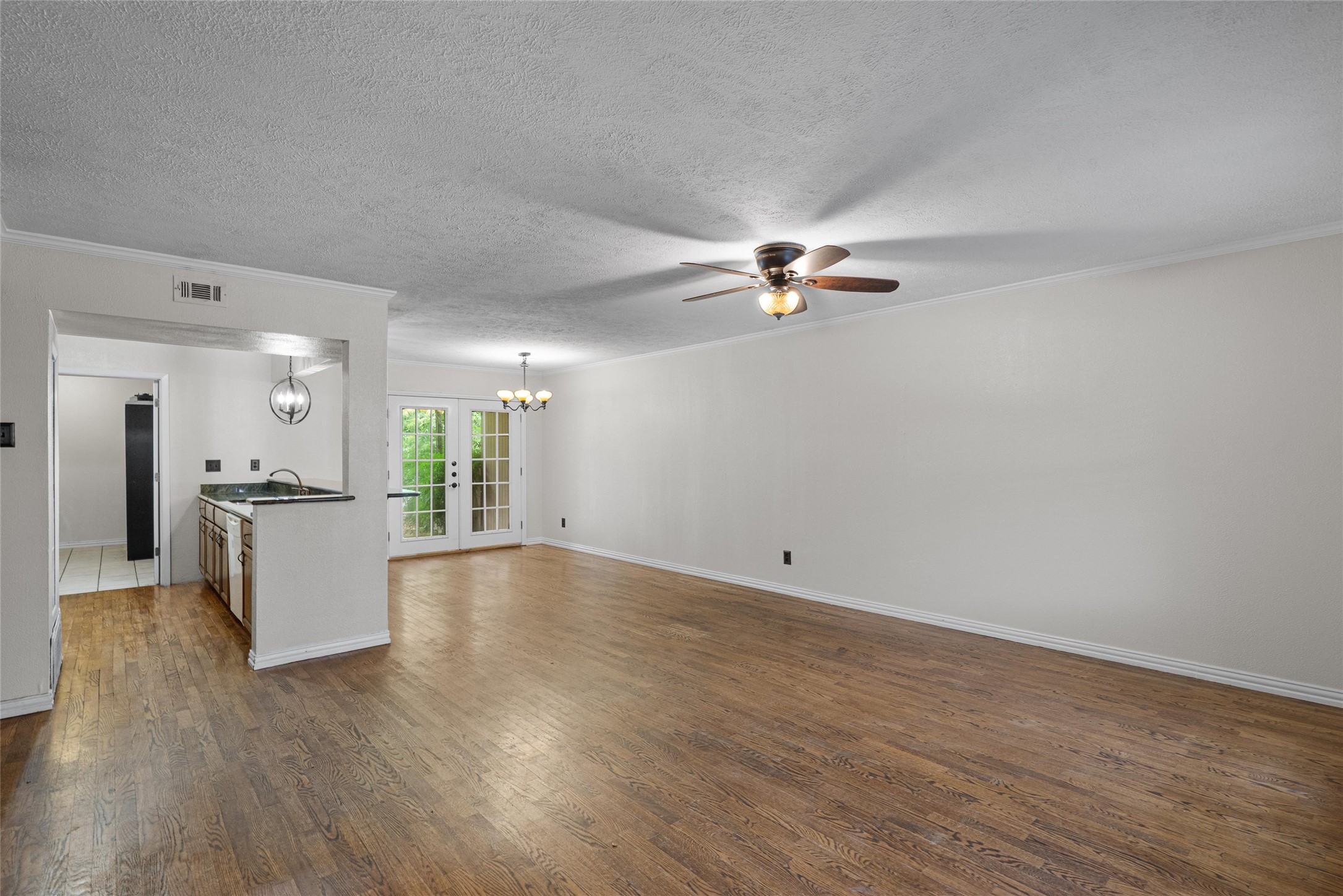 806 Castle Ridge Road, Unit C Austin, TX 78746 - Photo 3 of 28 Hardwood floors stretch across this inviting living area, complemented by French doors opening to outdoor serenity.