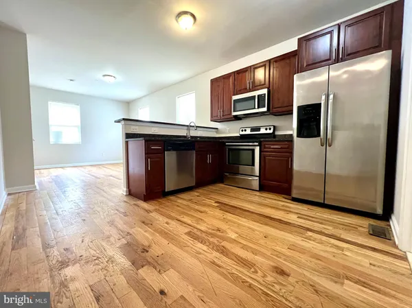 a kitchen with stainless steel appliances granite countertop a refrigerator and a stove