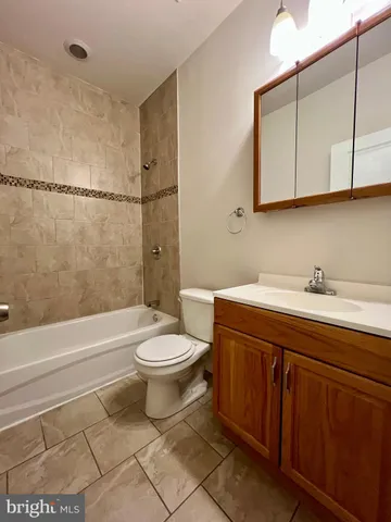 a bathroom with a toilet a sink a mirror and bathtub