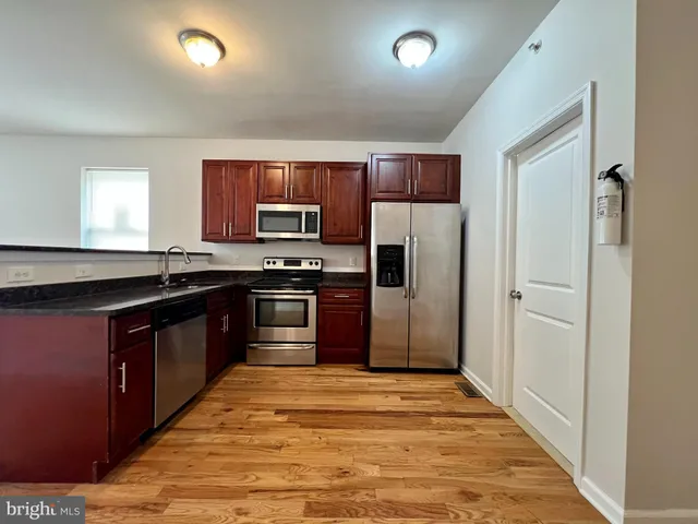 a kitchen with stainless steel appliances granite countertop a refrigerator and a stove