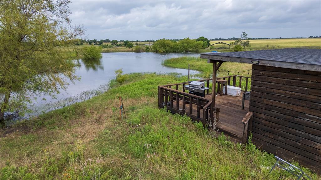340 Stevens Road Ennis, TX 75119 - Photo 16 of 18 a view of a lake with a table and chairs under an umbrella