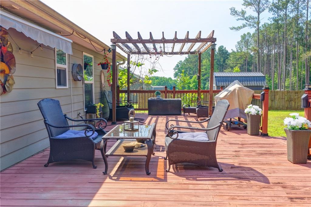 204 Lynn Road Bethlehem, GA 30620 - Photo 44 of 44 a view of a patio with table and chairs potted plants with wooden floor and fence