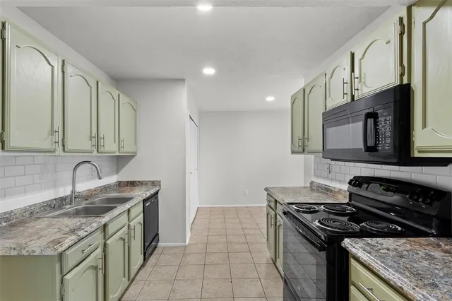 a kitchen with a sink stove top oven and cabinets