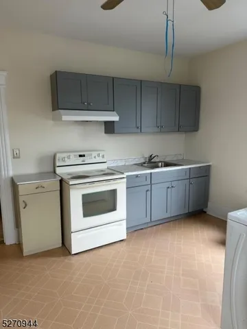a kitchen with stainless steel appliances a stove a sink and white cabinets