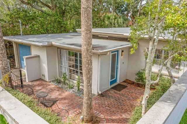a view of a chair and table in backyard of the house