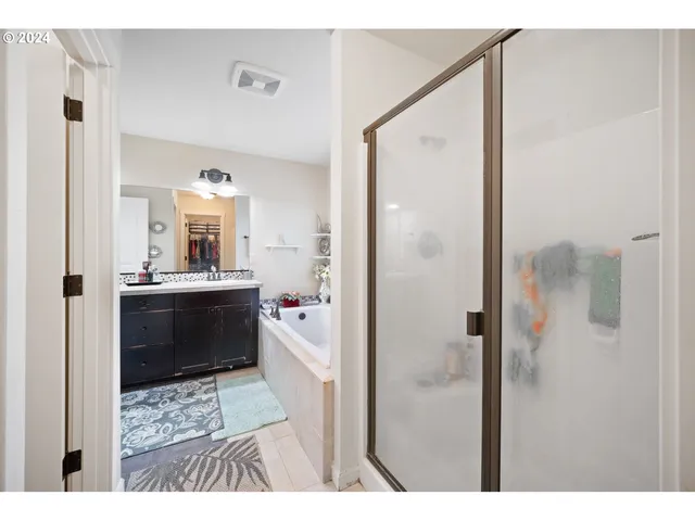 a bathroom with a double vanity sink a mirror and a shower